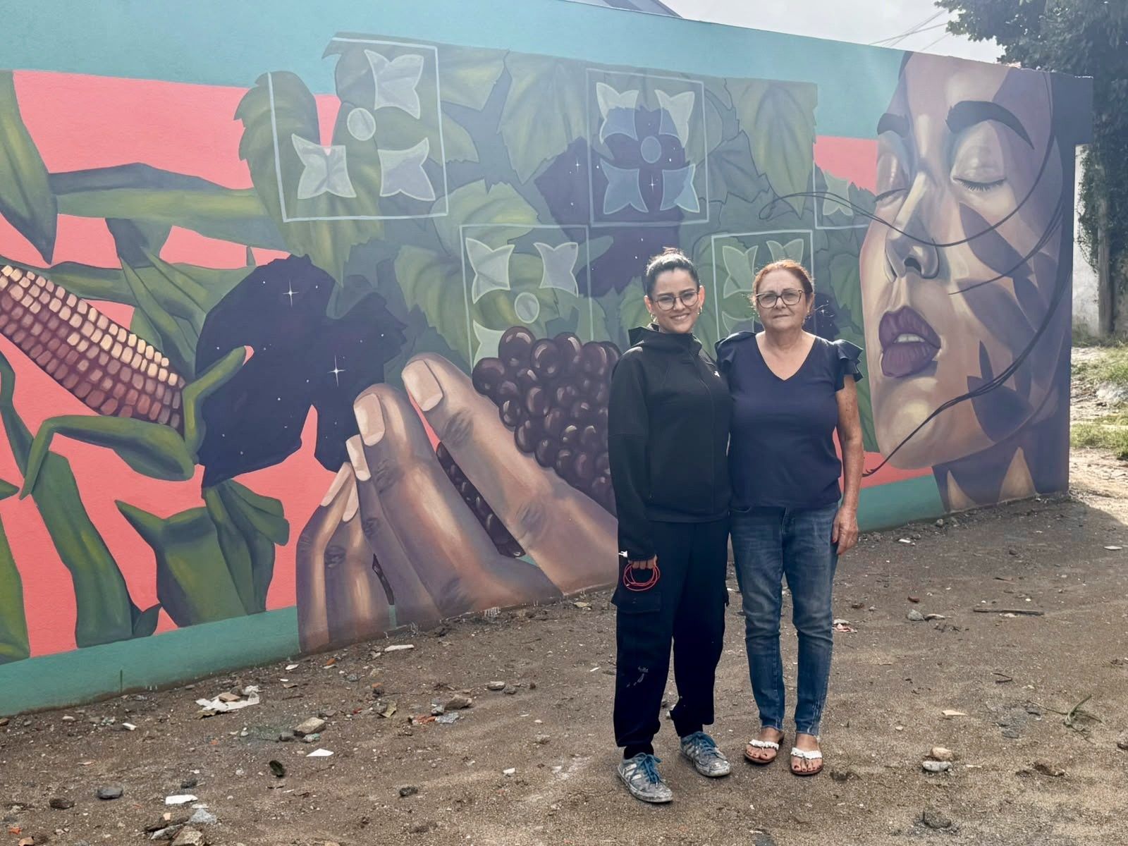 Victoria Akino and Dona Custódia in front of the Harvest Mural at StartArt
