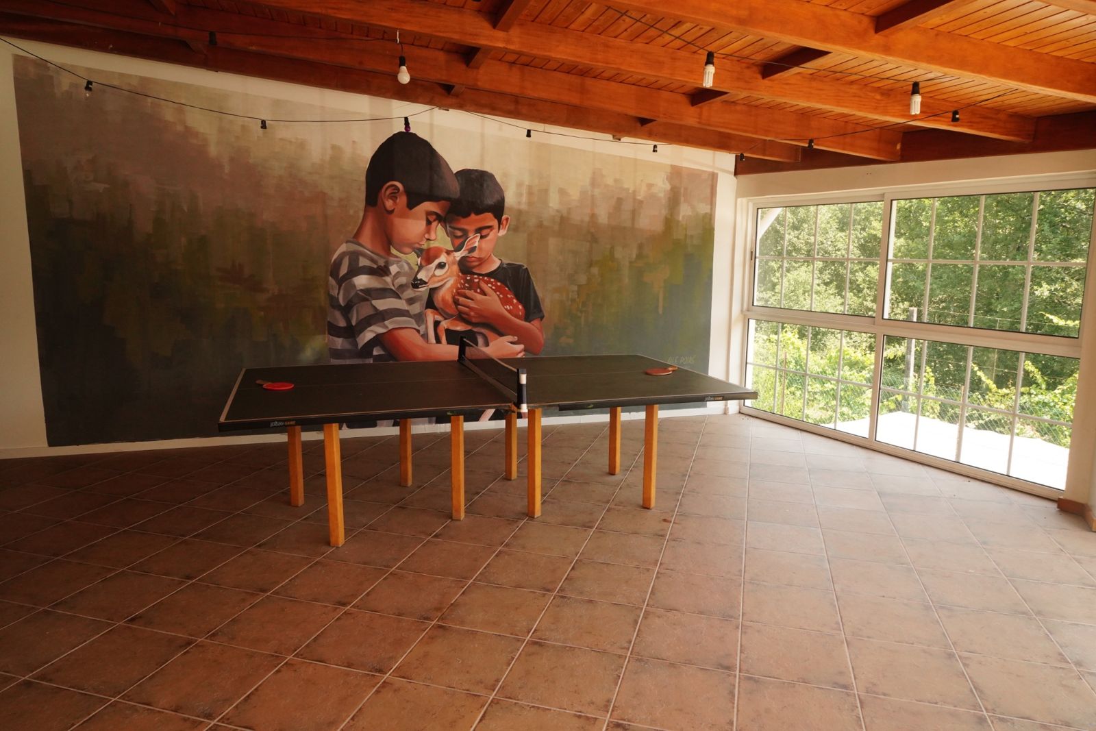 The games room at StartArt with a large painted mural by Ale Poire